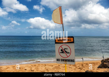 Non si può nuotare cartello segnaletico e bandiera rossa sulla spiaggia di Haleiwa, North Shore Oahu Foto Stock