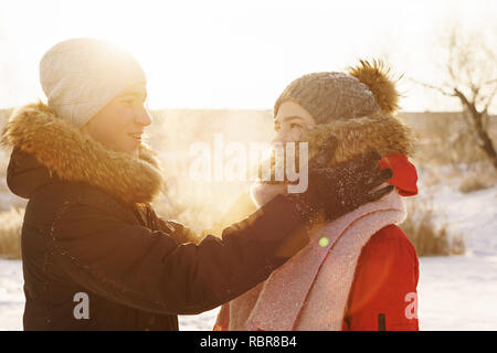 Contentissimo adolescenti a una data d'inverno. Ragazzo e ragazza stanno cercando in ogni altro. Concetto per il giorno di San Valentino. Foto Stock