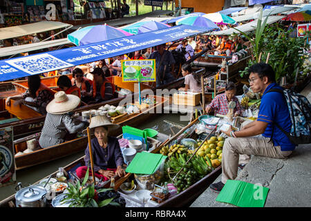 Ratchaburi, Tailandia - 27 Novembre 2018: Barche in canale vendono frutti per i turisti nel Mercato Galleggiante di Damnoen Saduak Foto Stock