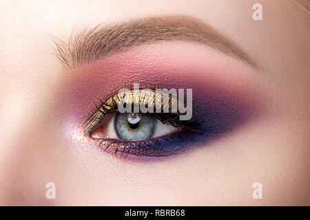 Close up di bella donna occhio con multicolore smokey eyes trucco. Moderna moda make up. Studio shot Foto Stock