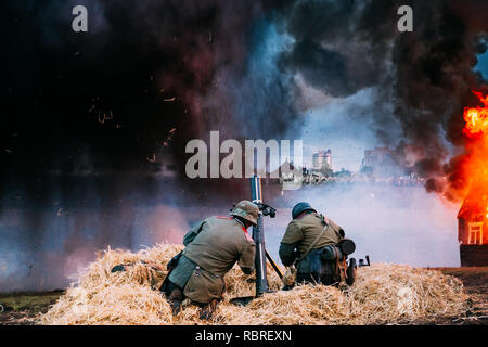 Unidentified Re-enactors vestita come la II guerra mondiale i soldati tedeschi sparati da un mortaio. Rievocazione della battaglia della Grande Guerra Patriottica in Bielorussia. Foto Stock