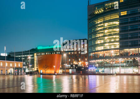 Helsinki, Finlandia. Cappella Kamppi o Cappella del silenzio in illuminazione serale sulla piazza Narinkka. Cappella azionato dalla parrocchia di Helsinki Unione sociale e Foto Stock