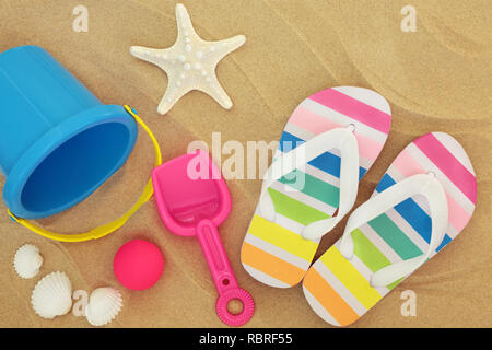 Vacanze estate spiaggia concetto con colorate flip flop, benna e vanga, sfera e conchiglie sulla sabbia. Foto Stock