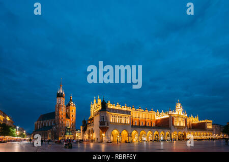 Cracovia in Polonia. Sera vista notturna di Santa Maria la Basilica e il panno Hall edificio. Famoso punto di riferimento vecchia chiesa della Madonna Assunta in Cielo. UNESCO Foto Stock