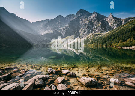 Parco nazionale dei Alti Tatra, Polonia. Famose Montagne Lago Morskie Oko o occhio di mare lago nella mattina d'estate. Bellissima Alba Sunray sopra il lago di tatra Landscap Foto Stock