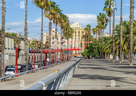 Barcellona, Spagna - 10 Novembre 2018: Passeig de Colom, un ampio viale alberato fiancheggiato da palme, con un ponte rosso su strada la visualizzazione direzione Foto Stock