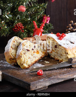 Europea tradizionale Stollen con torta di noci e frutta candita su una tavola di legno, close up Foto Stock