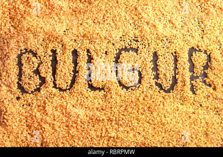 Il lettering Bulgur dai grani di bulgur whrat su sfondo nero Foto Stock