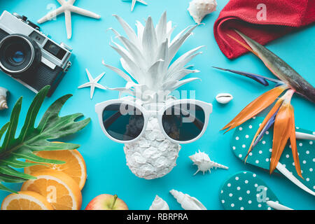 Concetto di estate con ananas e occhiali da sole e accessori di elemento di vacanza su sfondo blu.giorno felice e idee divertenti Foto Stock