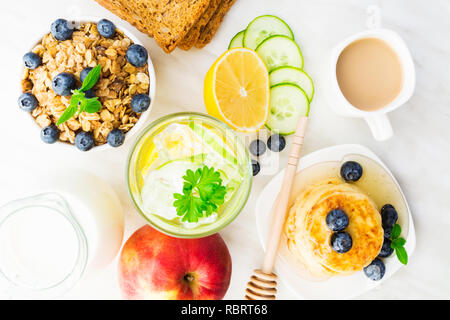 Vista aerea di una sana colazione con acqua detox, muesli, frutta e caffé, laici piatta Foto Stock