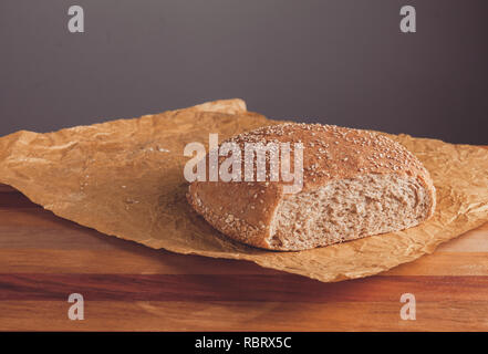 Pane appena sfornato pagnotta di pane integrale con crusca sulla carta da forno. Stock Photo Foto Stock