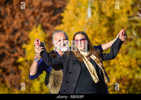 Felice coppia di anziani godendo la vita in un luminoso e soleggiato, giorni di autunno Foto Stock