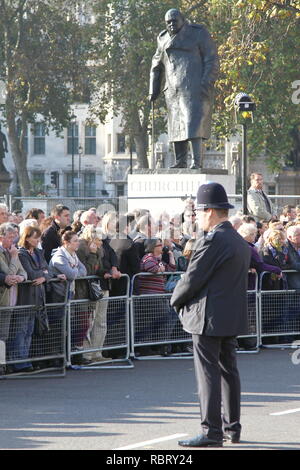Sir Winston Churchill Statua in piazza del Parlamento, a Londra e a molte persone che frequentano il ricordo della domenica. Foto Stock