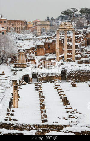 Inverno a Roma. Vista del Foro Romano le antiche rovine e il Colosseo con neve Foto Stock