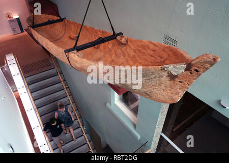 Il vecchio tradizionale canoa in legno di provenienza sconosciuta che si è incagliata su una spiaggia di Daintree, appeso su scala al museo di Cairns, Queensland, AUstra Foto Stock