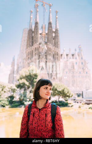 Barcellona, Spagna. Ritratto del Caucaso bella donna sulla Basilica di sfondo e chiesa espiatorio della Santa Famiglia o la Sagrada Familia in giornata soleggiata. Foto Stock