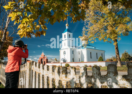 Luzhki, regione di Vitebsk, Bielorussia. Donna fotografata Chiesa Ortodossa della Natività della Vergine. Turistica prendendo le foto sulla fotocamera. Foto Stock