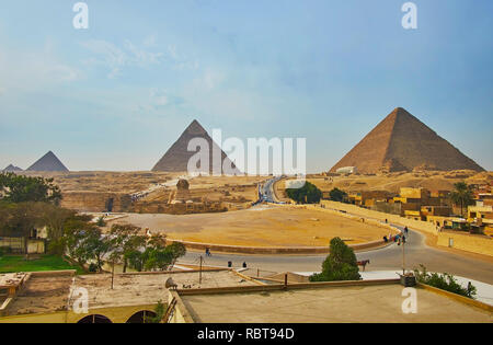 Iconico skyline di Giza con le piramidi di necropoli e la statua di Sphinx tra le sabbie del deserto, Egitto. Foto Stock