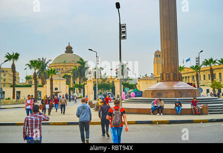 GIZA, Egitto - 19 dicembre 2017: la folla di gente in Nahdet Masr piazza davanti al scenico e storico edificio della Facoltà delle Arti del Cairo Univer Foto Stock