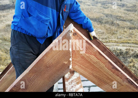 Il lavoratore uccide il chiodo di puntoni sulla parte superiore del tetto della casa Foto Stock