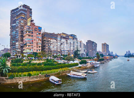 GIZA, Egitto - 19 dicembre 2017: la zona residenziale di alta sorge di Al Doqi di vicinato e la linea di giardini ornamentali lungo la riva del fiume Nilo, o Foto Stock