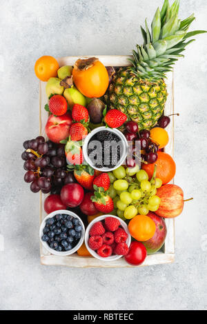 Cesto di frutta con un ananas, mele, banane e fragole su un tavolo di legno  Foto stock - Alamy