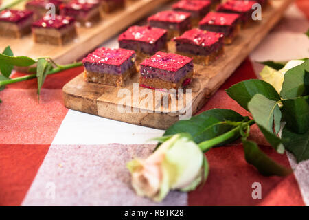 Visualizzazione della bella dolce torte in miniatura con una rosa bianca Foto Stock
