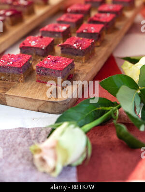Visualizzazione della bella dolce torte in miniatura con una rosa bianca Foto Stock