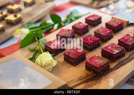 Visualizzazione della bella dolce torte in miniatura con una rosa bianca Foto Stock