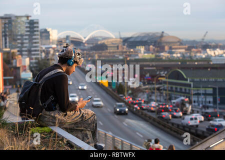 Seattle, Washington, Stati Uniti d'America. Xi gen, 2019. Un giovane visitatore si rilassa al Pike Place MarketFront durante la finale il tramonto sul modo in Alaska viadotto. L'autostrada chiuso definitivamente alle 22.00 il 11 gennaio in modo equipaggi può spostare Statale Route 99 dal viadotto per un sistema allo stato dell'arte di tunnel. Gli anni cinquanta-ser double-decker freeway è stato gravemente danneggiato nel 2001 Nisqually terremoto ed è stato mantenuto a lungo al di là della sua vita utile. Un due-miglio lungo, annoiato galleria stradale è la sostituzione del modo in Alaska viadotto, portando Statale Route 99 al di sotto del centro di Seattle dal sodo quartiere a sud il Lago Union. Credi Foto Stock