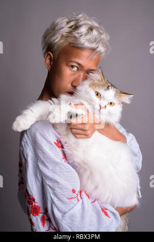 Giovane bella donna con capelli corti azienda gatto persiano Foto Stock