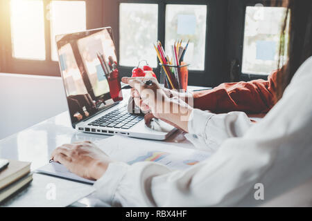 Il team di Business analizzando il reddito tabelle e grafici con i moderni computer laptop e utilizzo di smart phone. Vista superiore vicino. Analisi del business e strategia Foto Stock