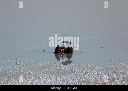 Una famiglia seduta sulla distesa di sale del lago di Urmia, West Azerbaijan provincia, Iran Foto Stock