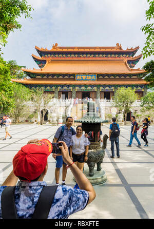 Un turista prende una foto di persone al Monastero Po Lin, Isola di Lantau, Hong Kong Foto Stock