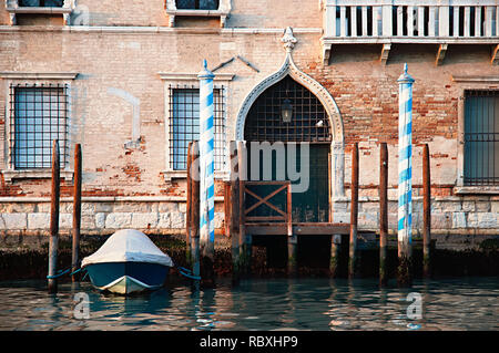 Visione dettagliata di un antico palazzo veneziano con una barca parcheggiata. Foto scattata da una barca turistica sul Canal Grande a Venezia, Italia. Foto Stock