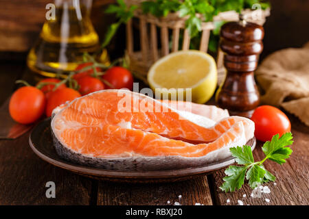La cottura di due crudo fresco salmone tranci di pesce su legno tavolo rustico closeup Foto Stock