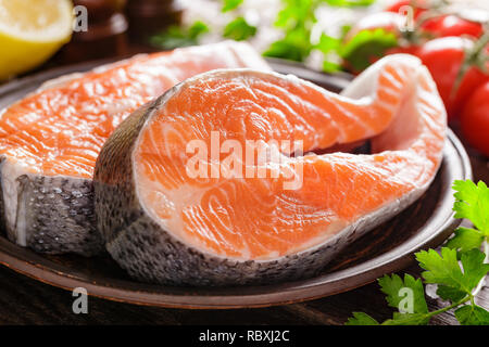 La cottura di due crudo fresco salmone tranci di pesce su legno tavolo rustico closeup Foto Stock