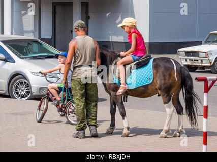 Voronezh, Russia - Agosto 12, 2018: Equitazione i bambini a cavallo nella moderna metropoli Foto Stock