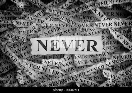 Mai. Pezzi di carta strappati con le parole mai. Concetto di immagine. In bianco e nero. Close up. Foto Stock