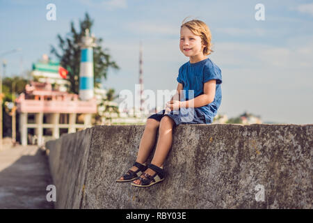 Ragazzo traveler sullo sfondo Dinh Cau faro simbolo dell'isola di Phu Quoc, Vietnam. Phu Quoc è un vietnamita isola al largo della costa della Cambogia i Foto Stock