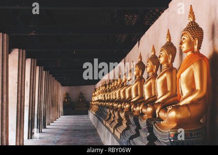 Righe di golden meditazione Buddha statue immagine attorno al tempio di Wat Phutthaisawan presso al parco storico di Ayutthaya, Ayutthaya, Thailandia. foto d'epoca Foto Stock