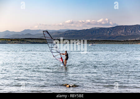 Windsurf in Soline Bay sull'Isola di Krk, Croazia. Alpi Dinariche visibile sulla baia in background. Foto Stock