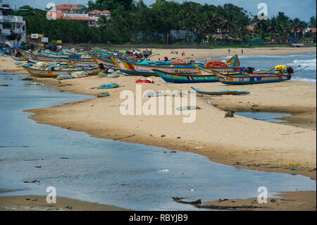 Barche da pesca in una spiaggia accanto a monumenti di Mahabalipuram Foto Stock