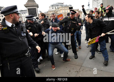 Gli ufficiali di polizia trattenere un dimostratore Pro-Brexit in Trafalgar Square, Londra, dove un rally organizzato dall'Assemblea popolare contro l'austerità sono riuniti. Foto Stock