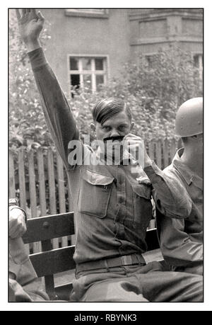 Momento umoristico della seconda guerra mondiale con un soldato americano che posa per una fotografia che imita il Reichsfuhrer nazista del terzo Reich Adolf Hitler. 1945. Un soldato americano sconosciuto in uniforme del servizio estivo che prende in giro i baffi di Hitler con un pettine per capelli. Raffigurato nella sua uniforme, un distintivo di combattente di fanteria e una medaglia di buona condotta. Seconda guerra mondiale Foto Stock