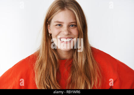 Close-up shot di affascinanti bell'aspetto carismatico amichevole giovane donna con lentiggini, fiera naturale dei capelli e gli occhi blu sorridente con gioia, divertirsi esprimendo il buon umore e le emozioni positive Foto Stock