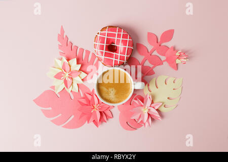 Vista da sopra con tazza di caffè, donut e moderno artigianato origami fiori di carta copia spazio. La donna il giorno 8 marzo. sfondo rosa. Donna e stilis Foto Stock