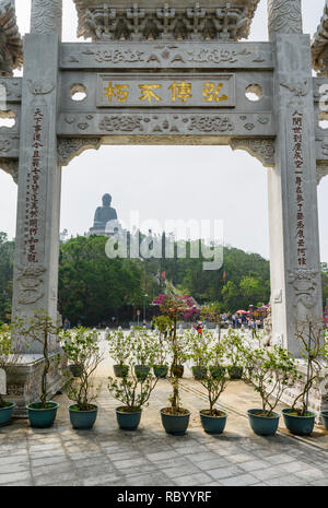 Vista incorniciata del Tian Tan Buddha attraverso il cancello di montagna e del distico letteraria presso il Monastero Po Lin, Isola di Lantau, Hong Kong Foto Stock