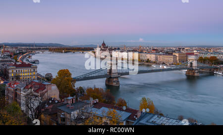Panorama del parlamento ungherese e il Ponte delle Catene (Szechenyi lanchid), oltre il Fiume Danubio, Budapest, Ungheria al tramonto Foto Stock