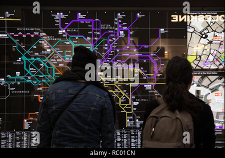 Passeggeri guardando ferrovia Mappa di Birmingham REGNO UNITO, Birmingham New Street Station concourse Foto Stock